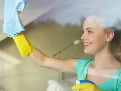 Seorang wanita sedang membersihkan kaca