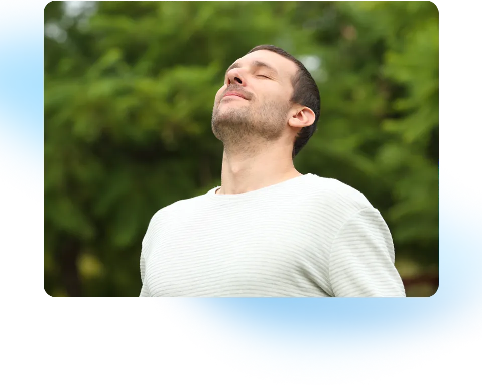 A man breathes in deeply through his nose.