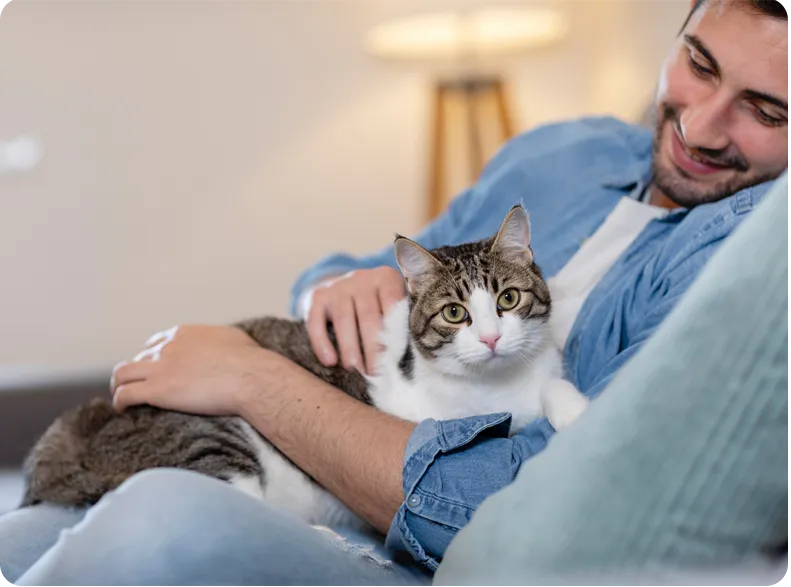 A man sits holding his cat