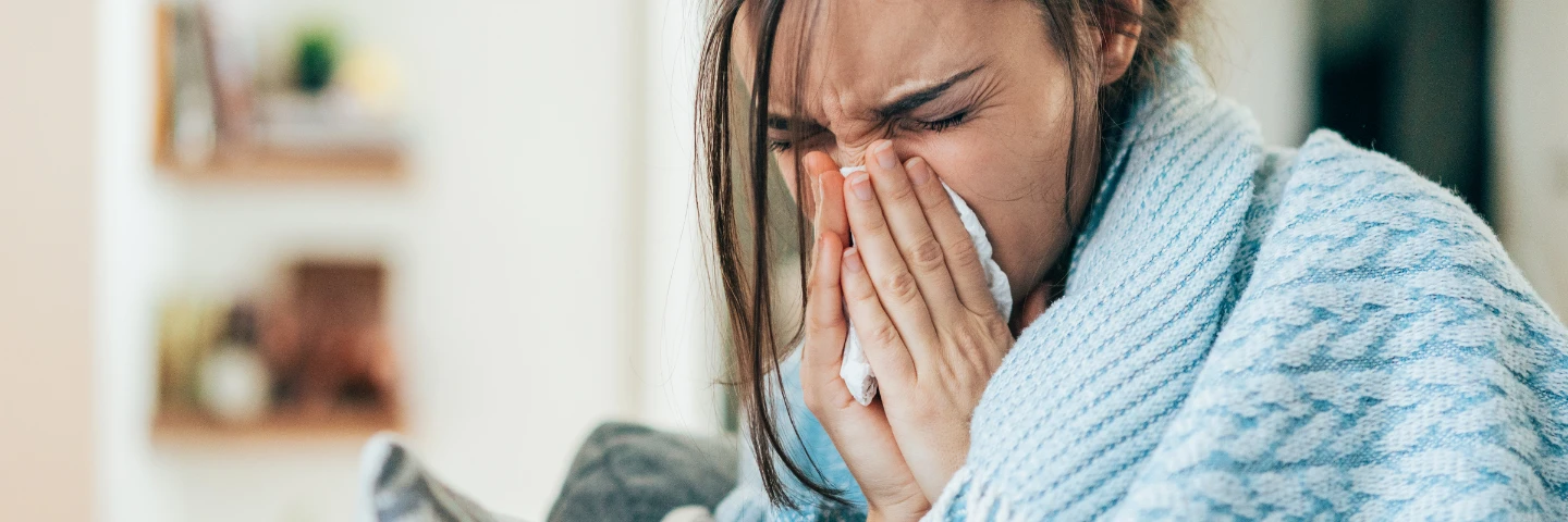 a woman with allergy symptoms in an outdoor setting 