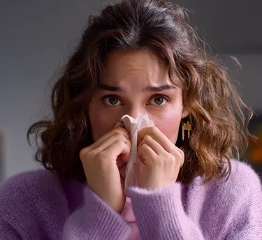 A woman blowing her nose