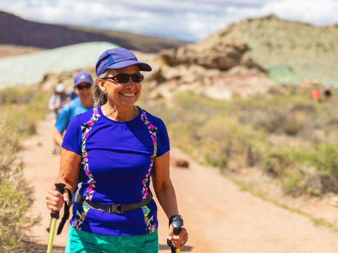 An image of a woman smiling while hiking.