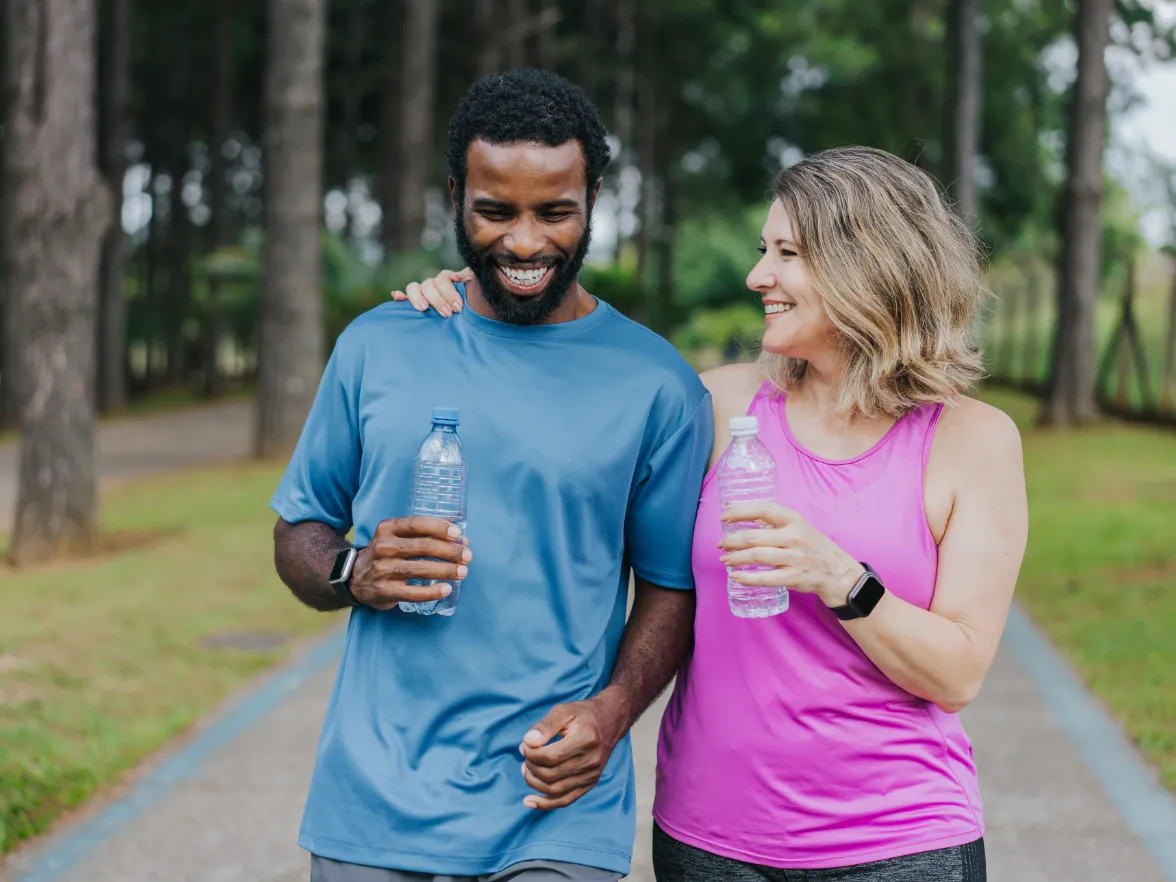 An image of a couple outside, smiling while on a walk.