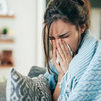 a woman with allergy symptoms in an outdoor setting 