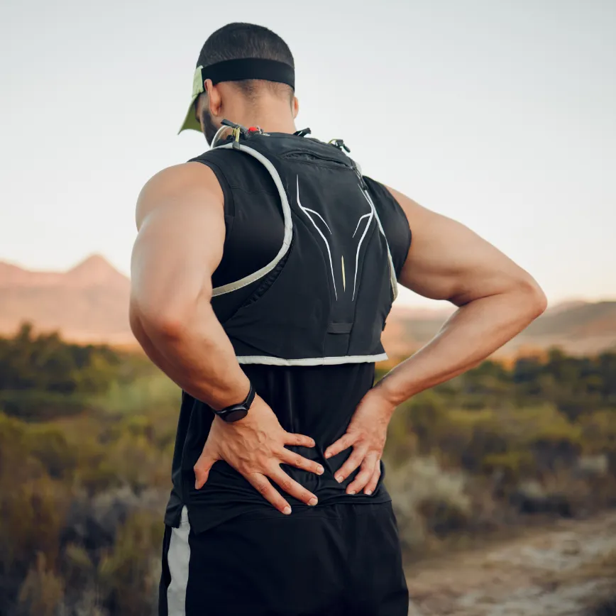 A man holding his back in pain or discomfort.