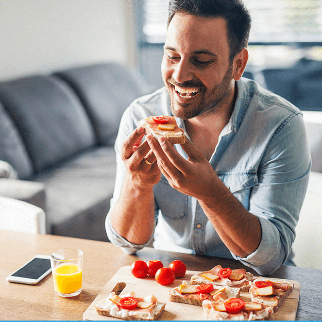 A man sitting while eating his breakfast happily.