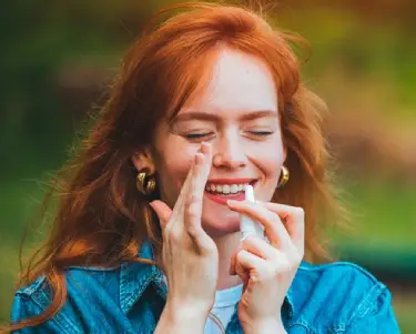 Frau die Augentropfen anwendet